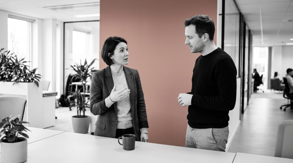 Deux collaborateurs échangeant sur la communication de leur entreprise dans un bureau